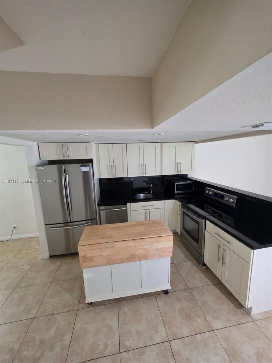 20200 West Country Club Drive, Unit 104 Aventura, FL 33180 - Photo 7 of 43 a kitchen with stainless steel appliances granite countertop a refrigerator and a sink