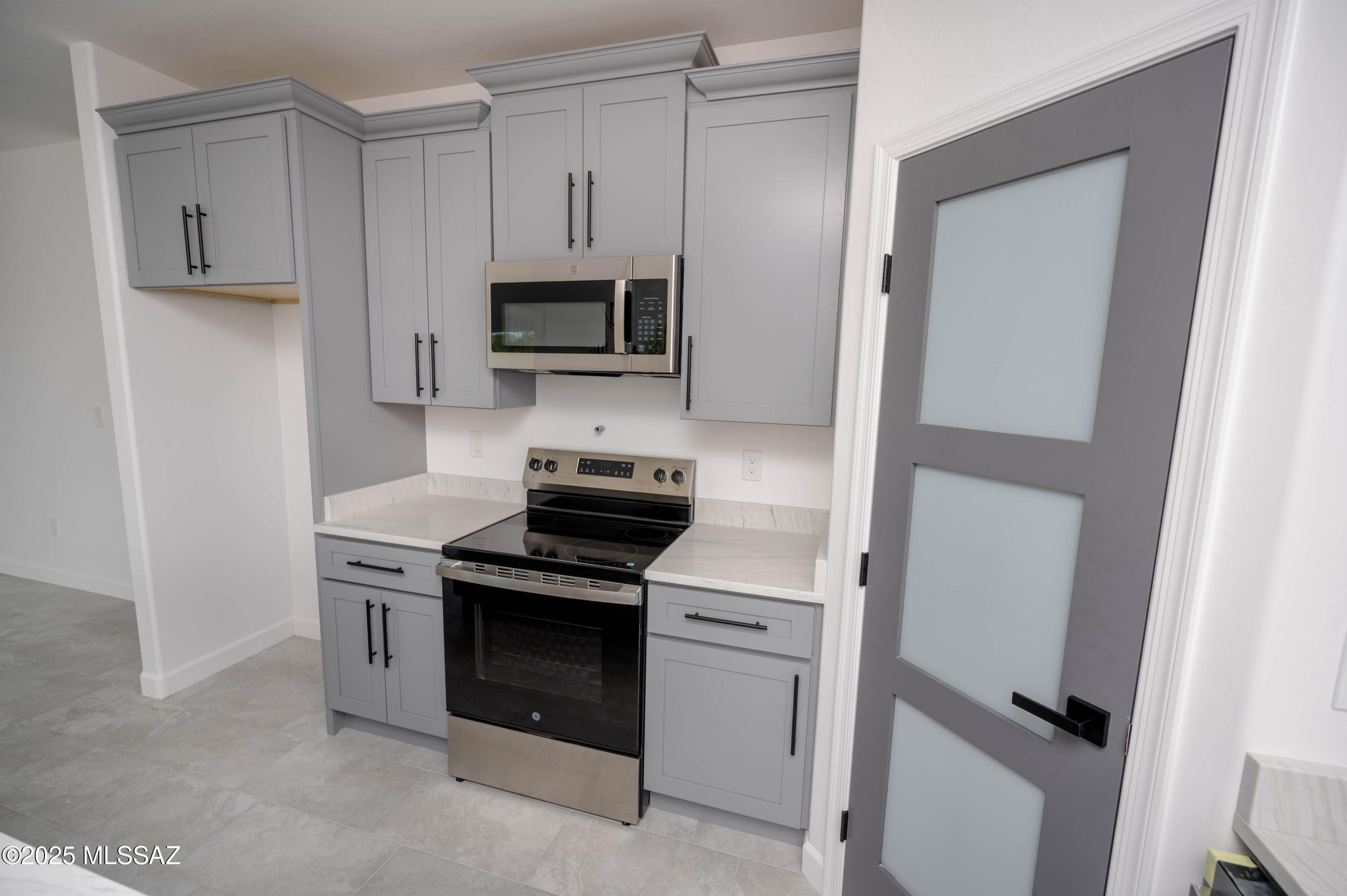 1781 Elder Court Rio Rico, AZ 85648 - Photo 43 of 50 a kitchen with white cabinets and stainless steel appliances