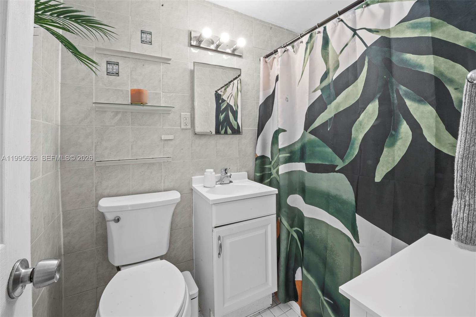 330 74th Street, Unit 5 Miami Beach, FL 33141 - Photo 9 of 19 a white toilet sitting next to a bathroom sink