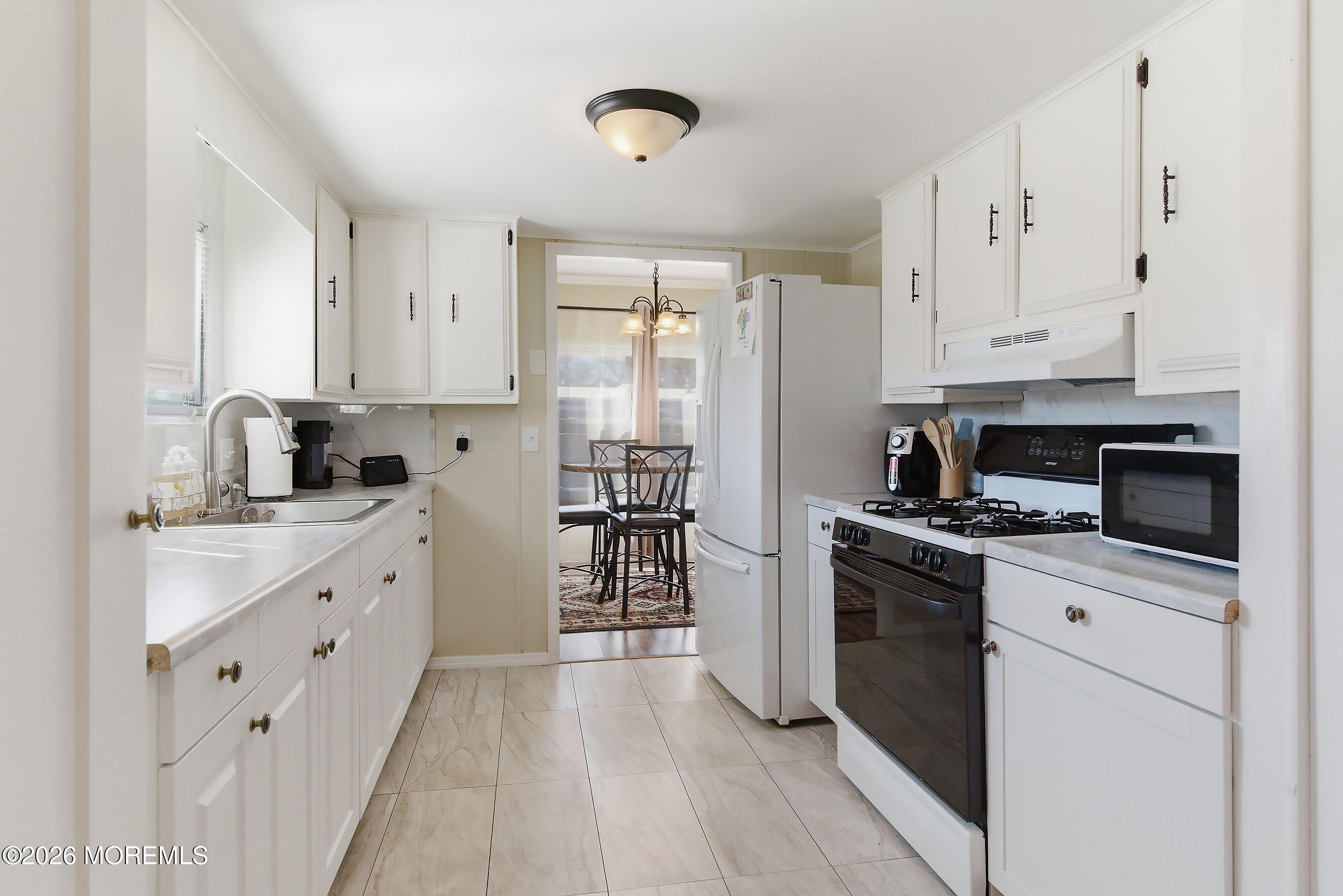 164 Camino Rio Toms River, NJ 08755 - Photo 13 of 36 a kitchen with stainless steel appliances granite countertop a stove top oven a sink dishwasher and a refrigerator with wooden floor