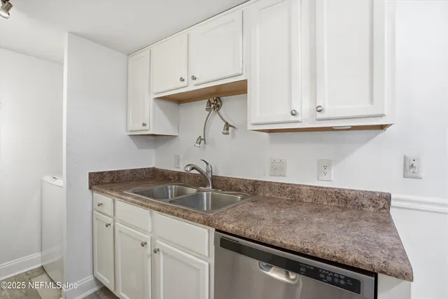 a kitchen with granite countertop white cabinets and a sink