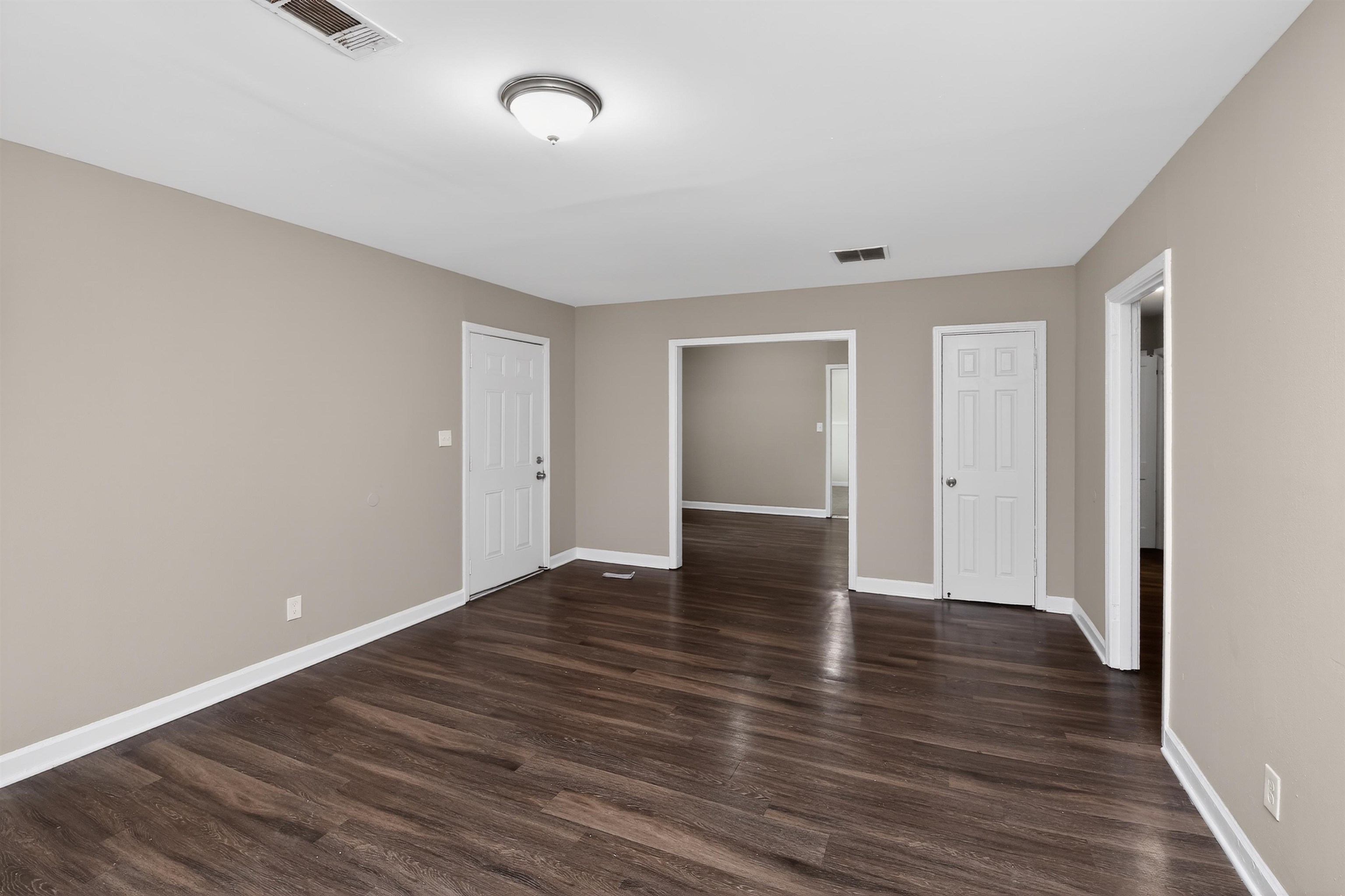 318 East Raines Road Memphis, TN 38109 - Photo 15 of 28 Spacious room featuring wood-finish flooring, neutral-toned walls, white trim, and multiple doorways
