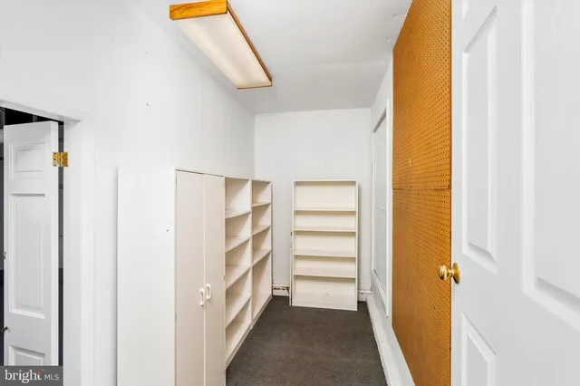 a view of walk in closet with empty racks