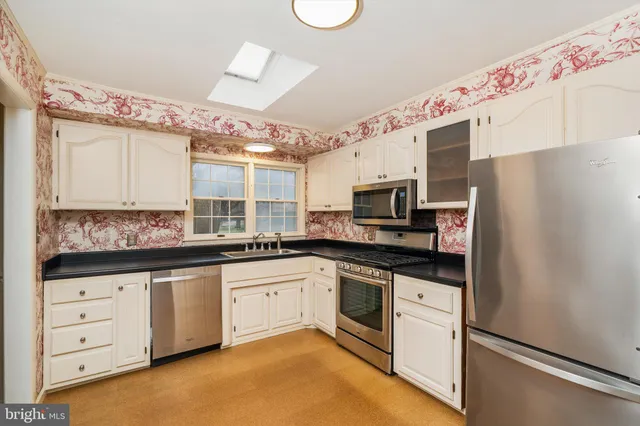 a kitchen with granite countertop a sink stainless steel appliances and cabinets
