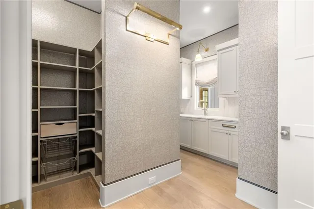 a view of a kitchen that shows a sink dishwasher and wooden floor