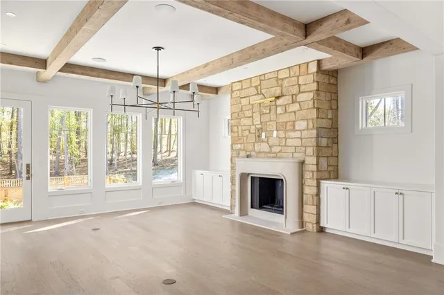 a view of an empty room with a fireplace and a window