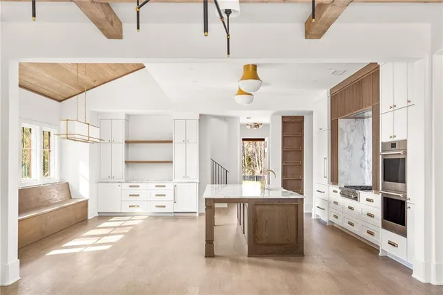 a large white kitchen with cabinets and a large window