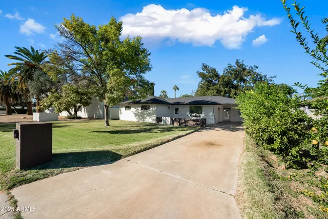 a view of a house with a yard and sitting area