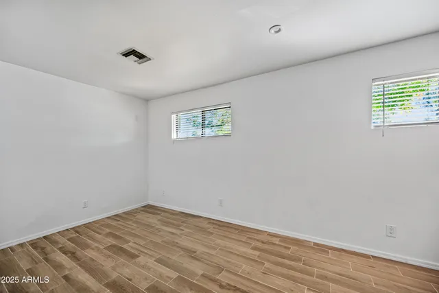 a view of empty room with wooden floor