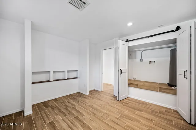 a view of empty room with wooden floor