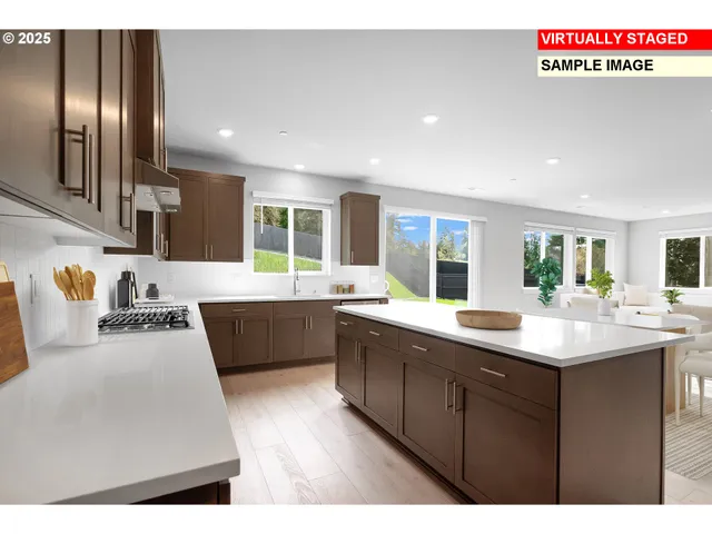 a large kitchen with stainless steel appliances kitchen island granite countertop a sink and cabinets
