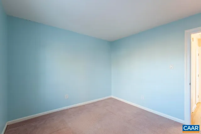 a front view of a building with cars parked