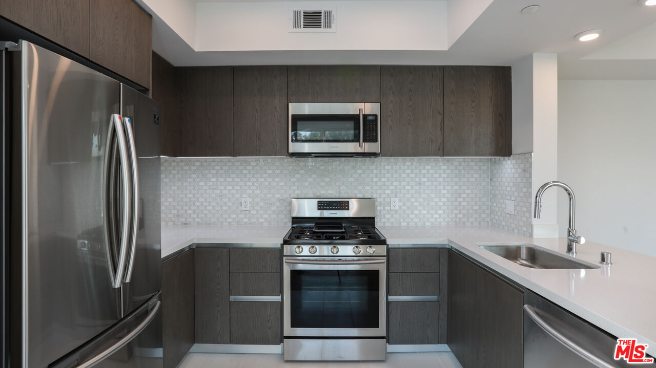 909 Le Doux Road, Unit 403 Los Angeles, CA 90035 - Photo 11 of 28 a kitchen with a refrigerator and a sink
