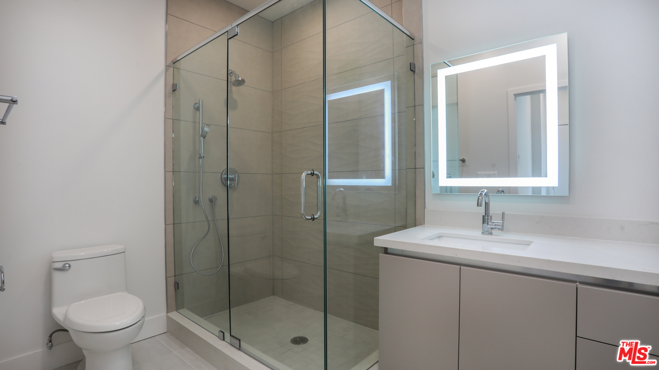 909 Le Doux Road, Unit 403 Los Angeles, CA 90035 - Photo 19 of 28 a bathroom with a shower sink vanity and toilet
