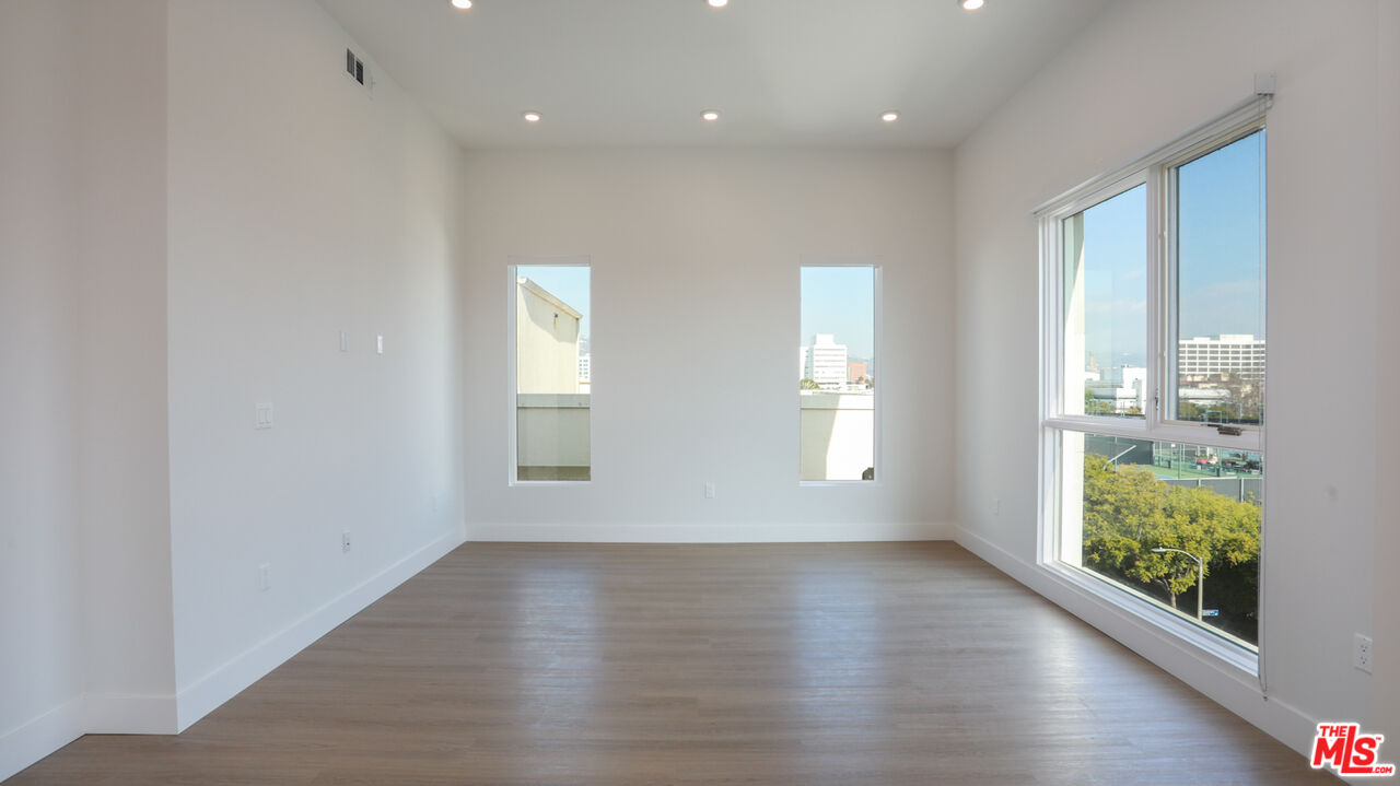 909 Le Doux Road, Unit 403 Los Angeles, CA 90035 - Photo 2 of 28 an empty room with wooden floor and windows