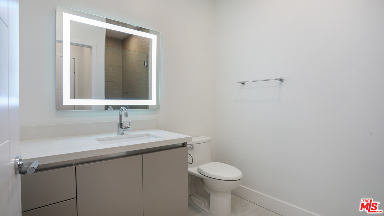 909 Le Doux Road, Unit 403 Los Angeles, CA 90035 - Photo 21 of 28 a bathroom with a toilet sink and mirror