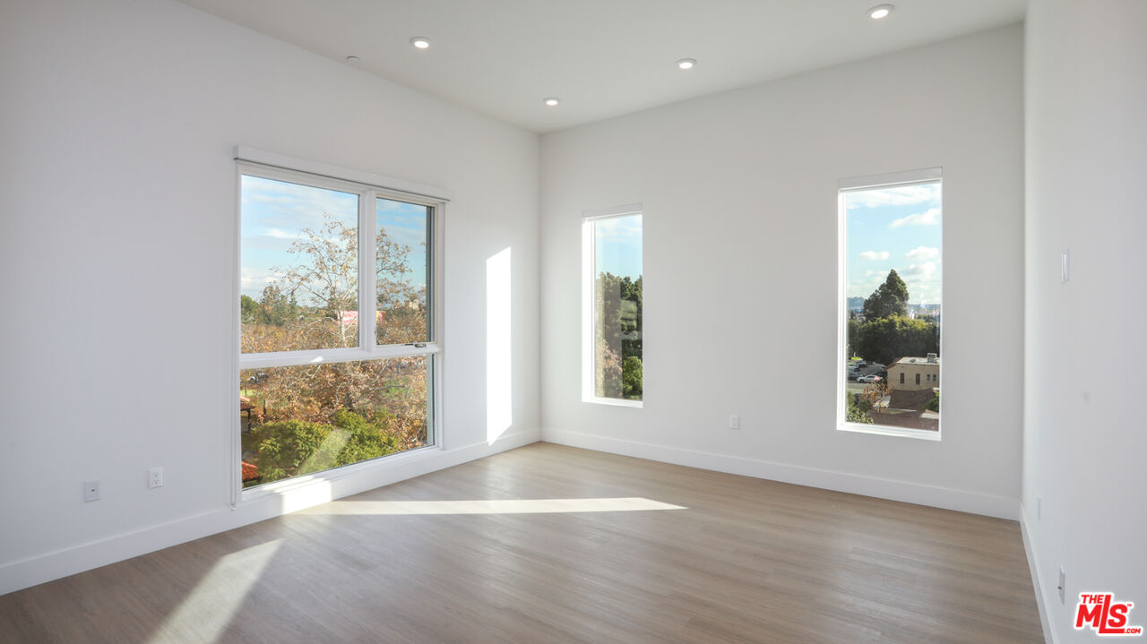 909 Le Doux Road, Unit 403 Los Angeles, CA 90035 - Photo 3 of 28 an empty room with wooden floor and windows