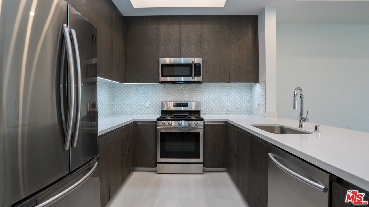 909 Le Doux Road, Unit 403 Los Angeles, CA 90035 - Photo 8 of 28 a kitchen with stainless steel appliances granite countertop a sink stove and refrigerator