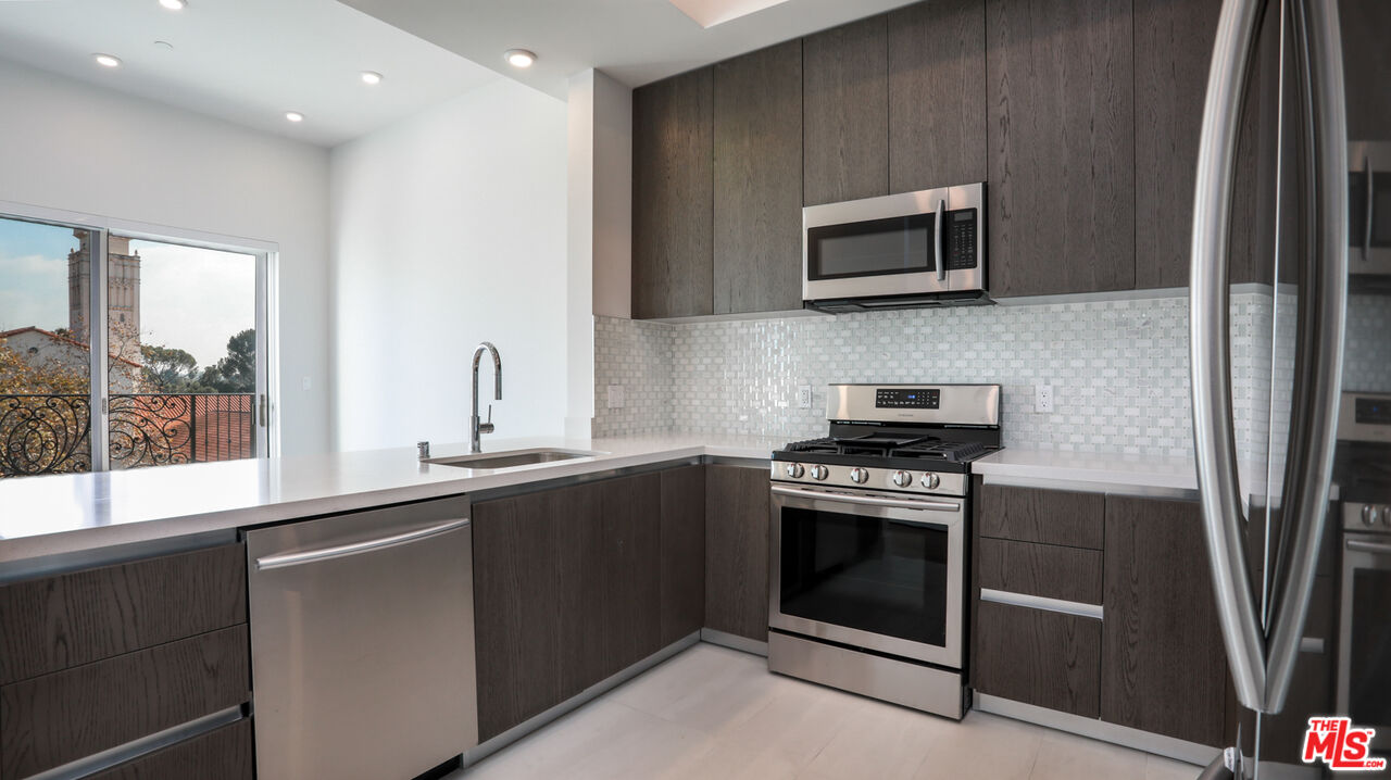 909 Le Doux Road, Unit 403 Los Angeles, CA 90035 - Photo 10 of 28 a kitchen with a stove and a microwave