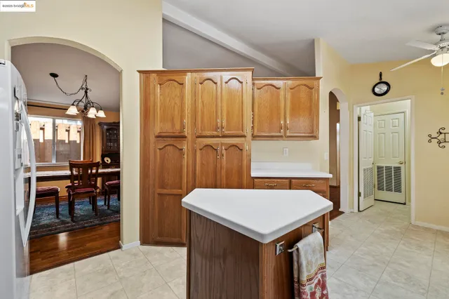 a kitchen that has a kitchen island wooden cabinets and refrigerator