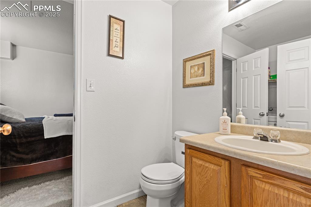 2000 Toronto Street Pueblo, CO 81004 - Photo 13 of 25 a bathroom with a granite countertop toilet a sink and a mirror