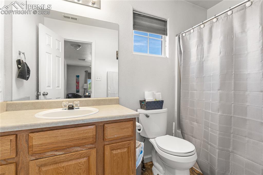2000 Toronto Street Pueblo, CO 81004 - Photo 16 of 25 a bathroom with a sink a toilet a mirror and shower curtain