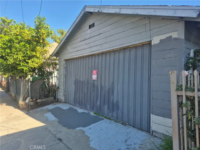 a view of a white house and a yard with table and chairs under an umbrella