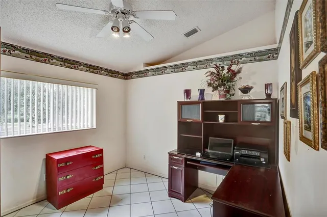 a view of an empty room with window chandelier fan and fire place