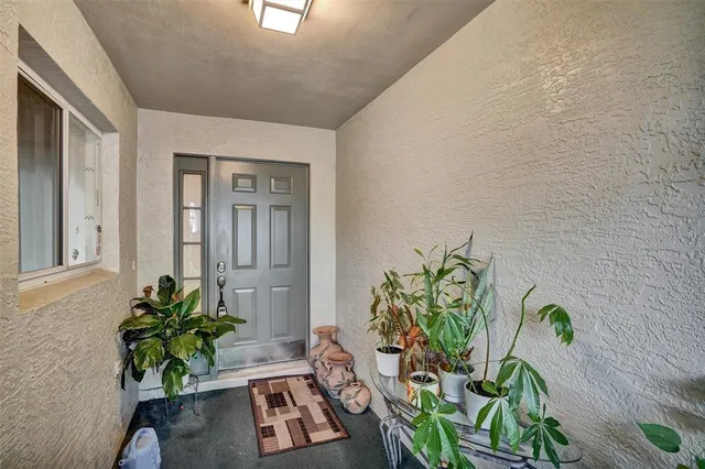a white vase with white and yellow flowers