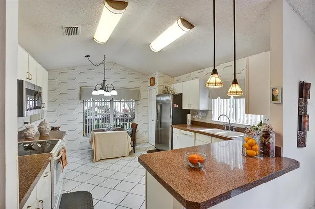 a kitchen with stainless steel appliances a sink stove and cabinets