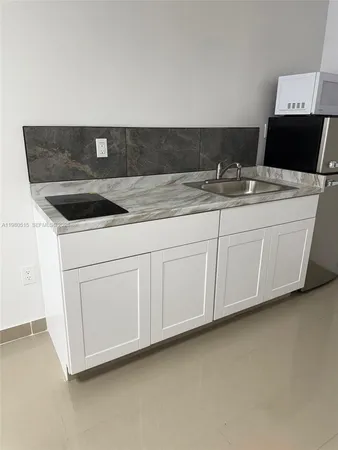 a kitchen with granite countertop white cabinets and white appliances