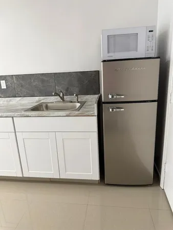 a kitchen with a refrigerator and cabinets