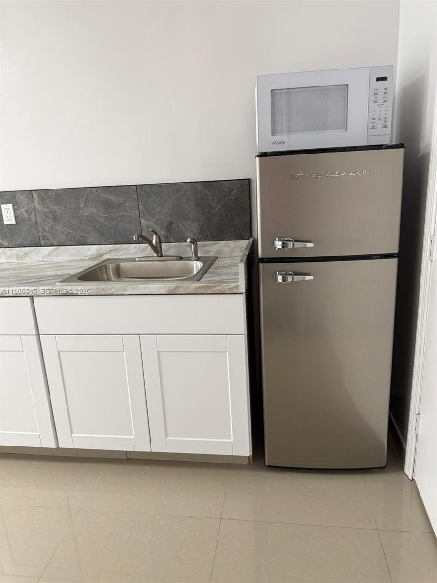 4700 Southwest 2nd Terrace, Unit 1 Miami, FL 33134 - Photo 3 of 8 a kitchen with a refrigerator and cabinets