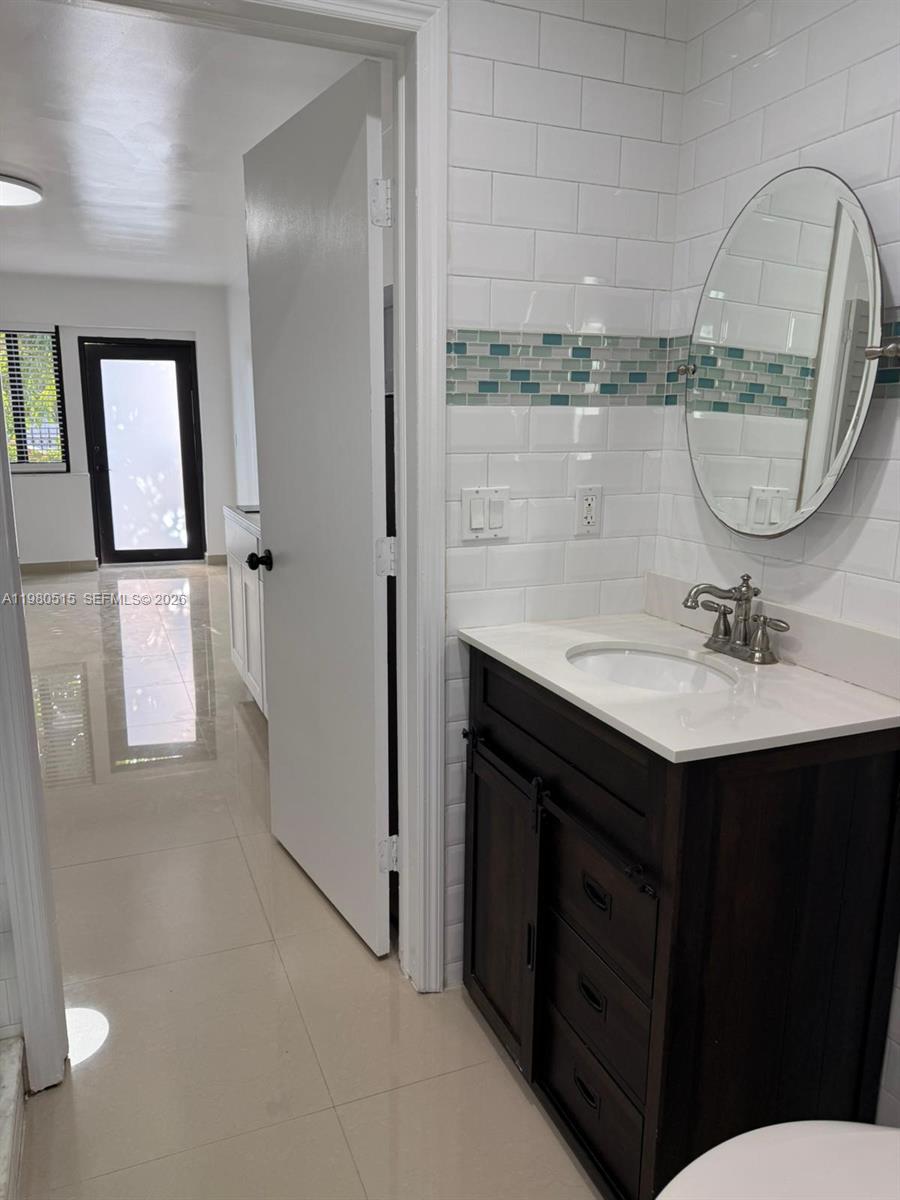 4700 Southwest 2nd Terrace, Unit 1 Miami, FL 33134 - Photo 4 of 8 a bathroom with a sink vanity granite and a mirror