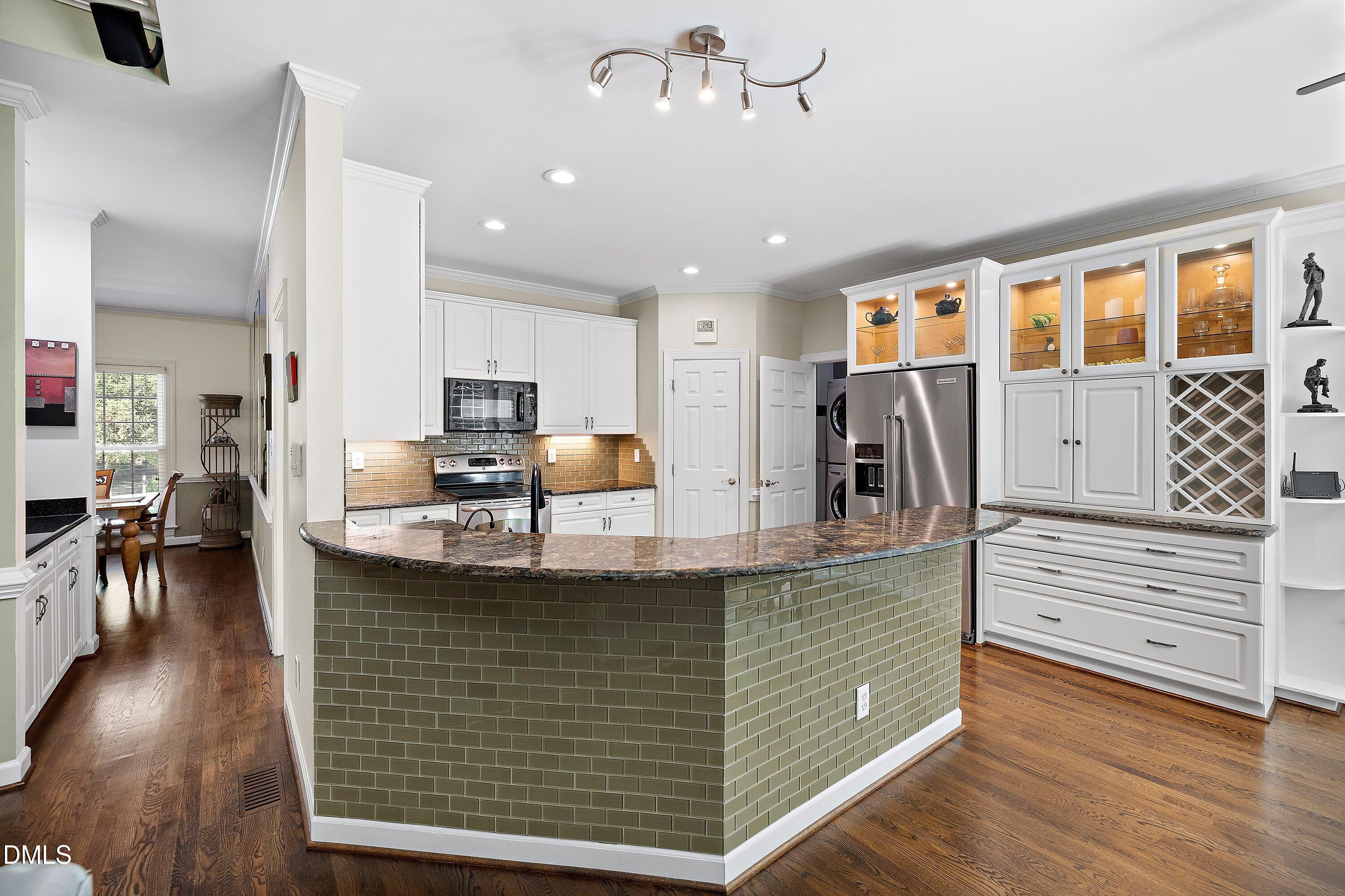 3608 Summer Leaf Court Raleigh, NC 27615 - Photo 18 of 63 a kitchen with kitchen island stainless steel appliances a sink and living room view
