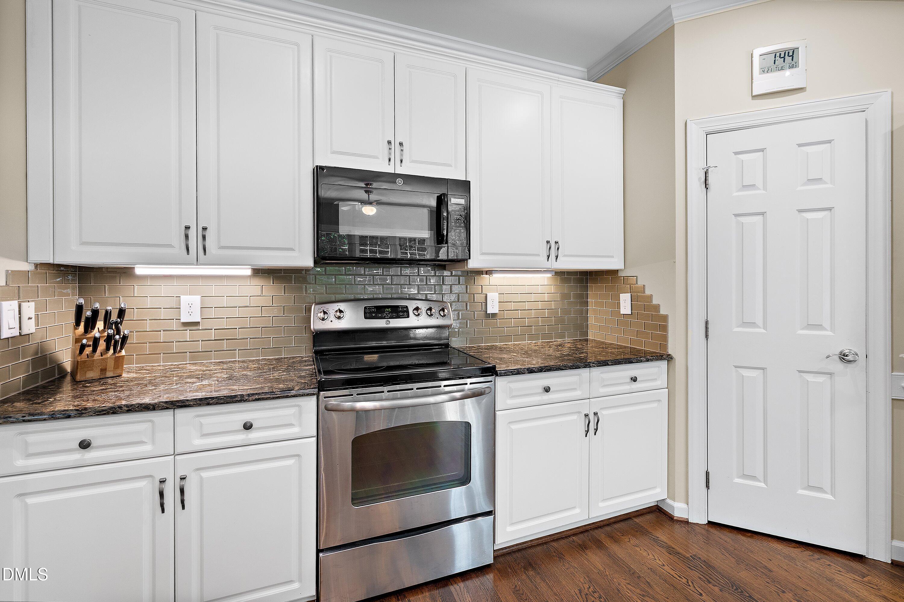 3608 Summer Leaf Court Raleigh, NC 27615 - Photo 24 of 63 a kitchen with granite countertop white cabinets and stainless steel appliances