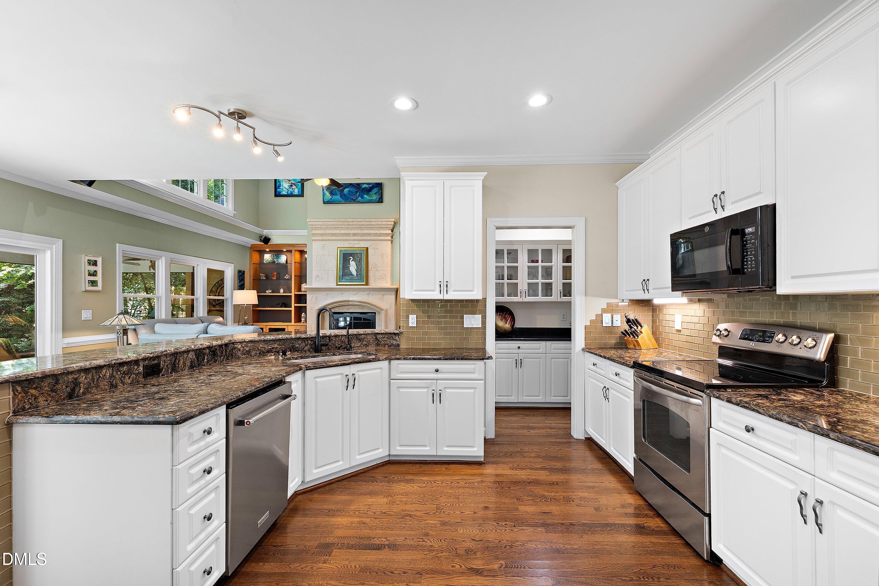 3608 Summer Leaf Court Raleigh, NC 27615 - Photo 25 of 63 a kitchen with stainless steel appliances granite countertop a sink and stove top oven