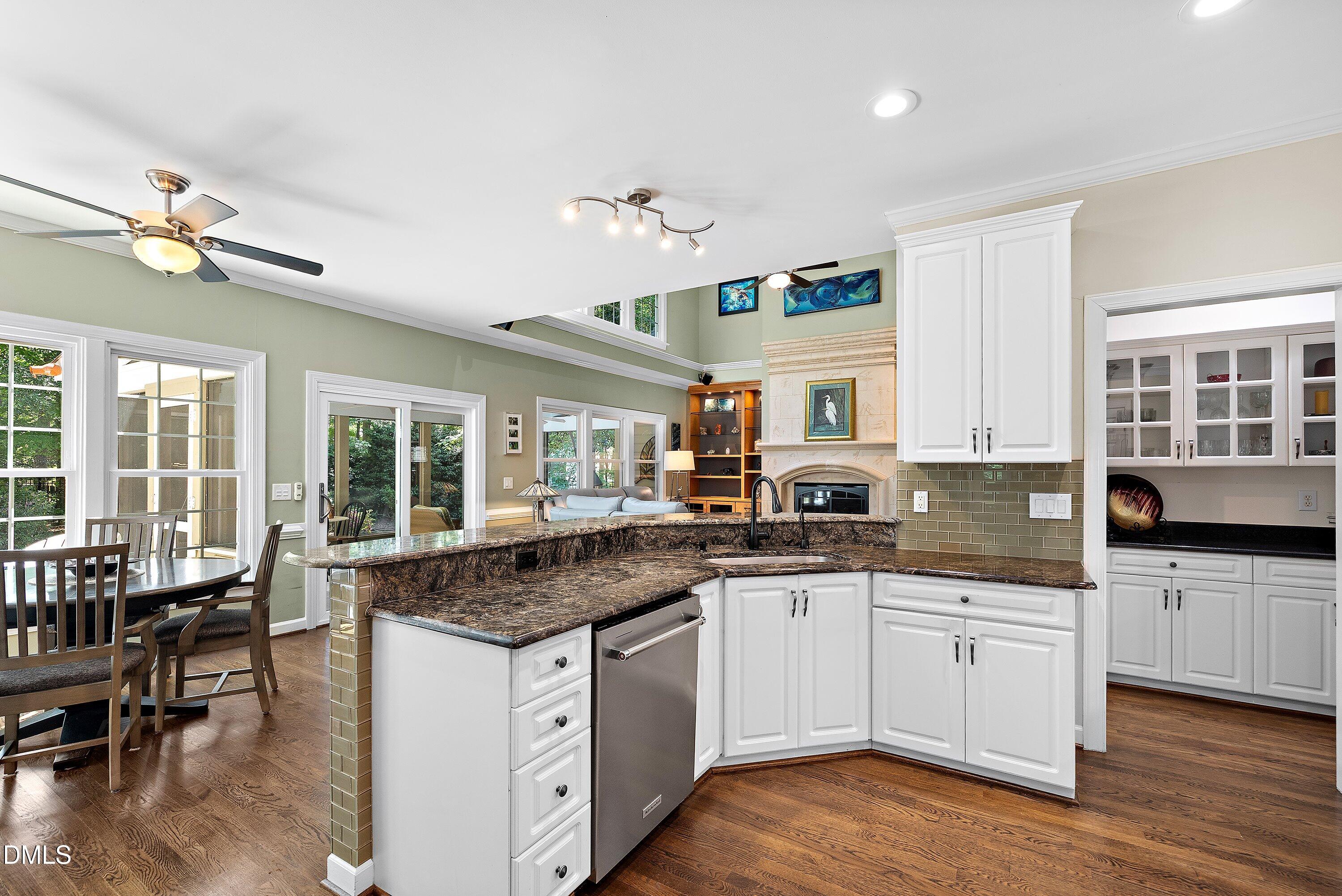 3608 Summer Leaf Court Raleigh, NC 27615 - Photo 26 of 63 a kitchen with granite countertop a sink and white cabinets with wooden floor