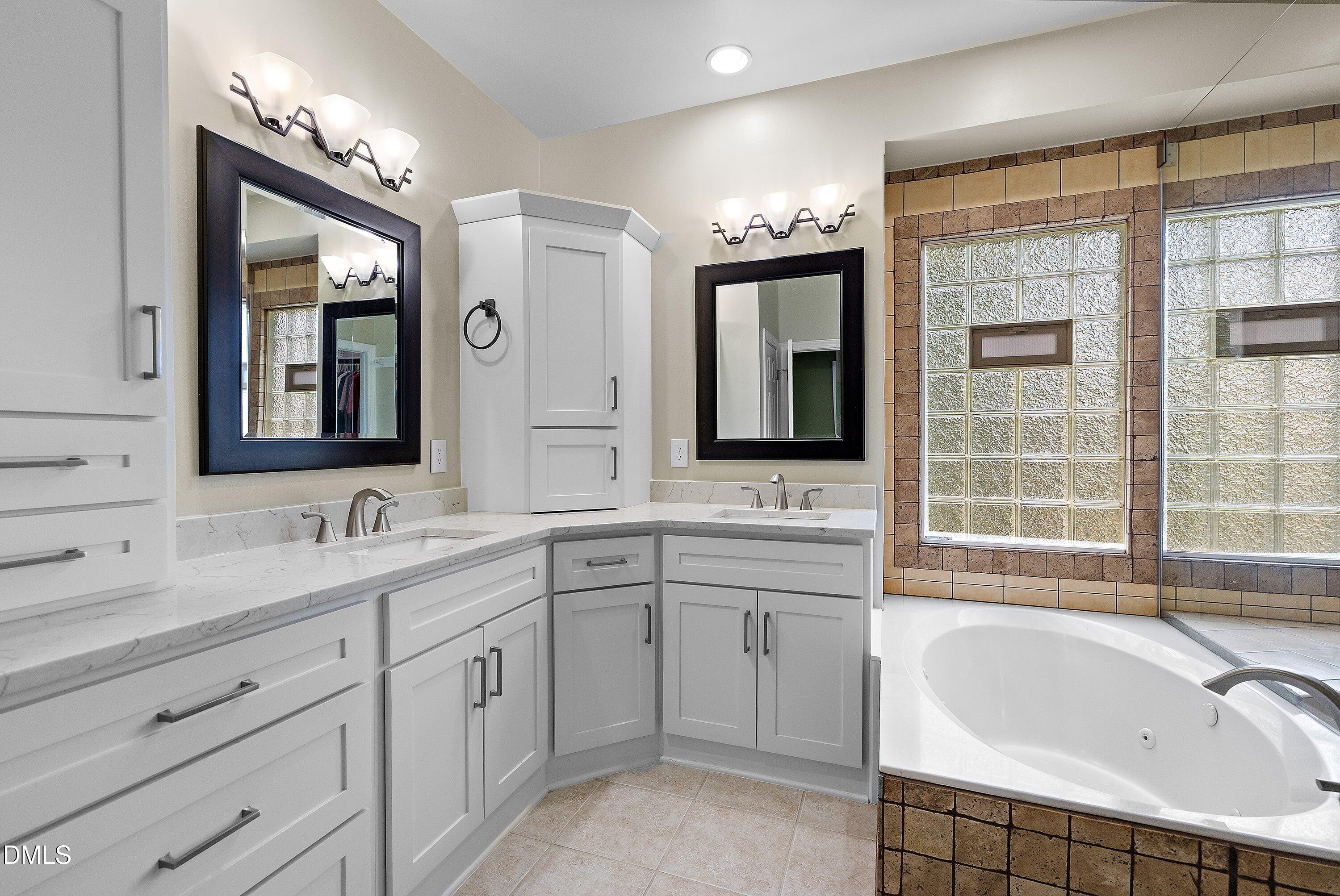 3608 Summer Leaf Court Raleigh, NC 27615 - Photo 34 of 63 a bathroom with a sink mirror and a bathtub