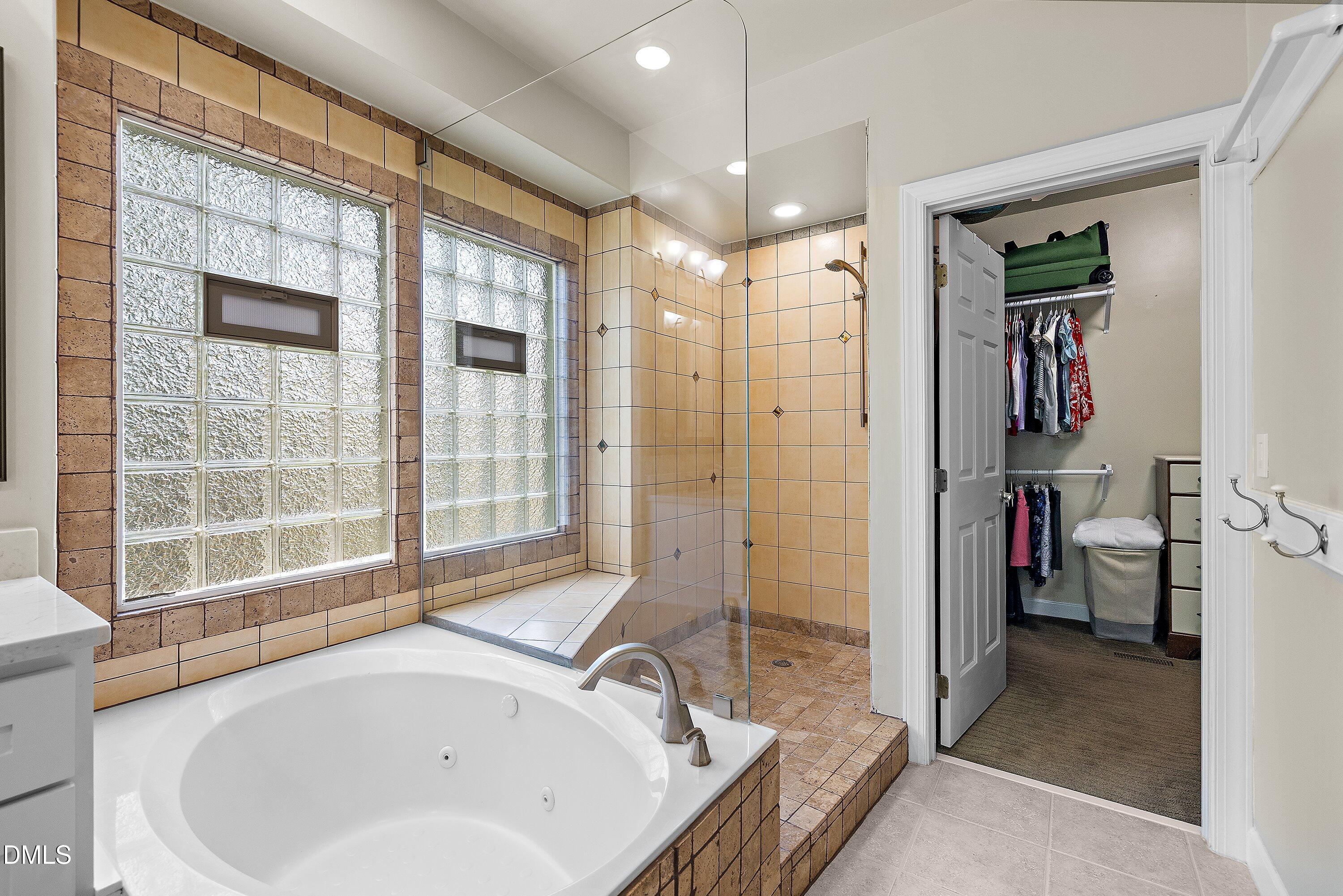 3608 Summer Leaf Court Raleigh, NC 27615 - Photo 35 of 63 a bathroom with a tub a sink and a large mirror