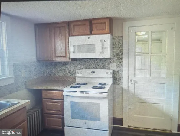 a kitchen with granite countertop white cabinets and white appliances