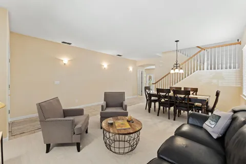 a living room with furniture and a chandelier