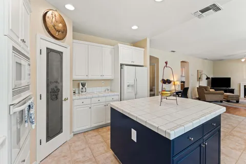 a kitchen with stainless steel appliances granite countertop a sink a refrigerator and a stove