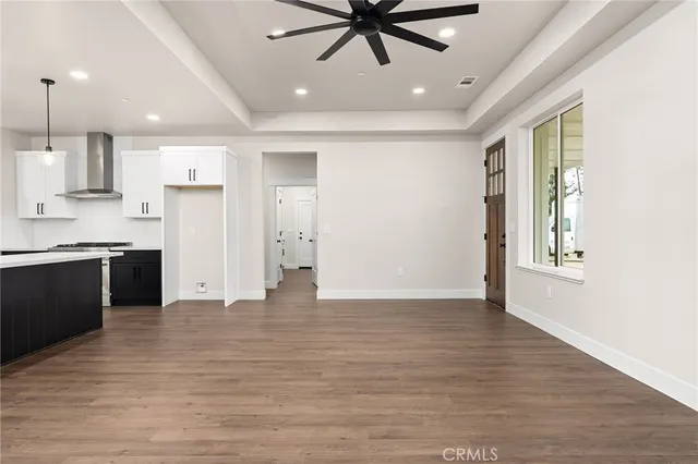 a view of an empty room with window and wooden floor