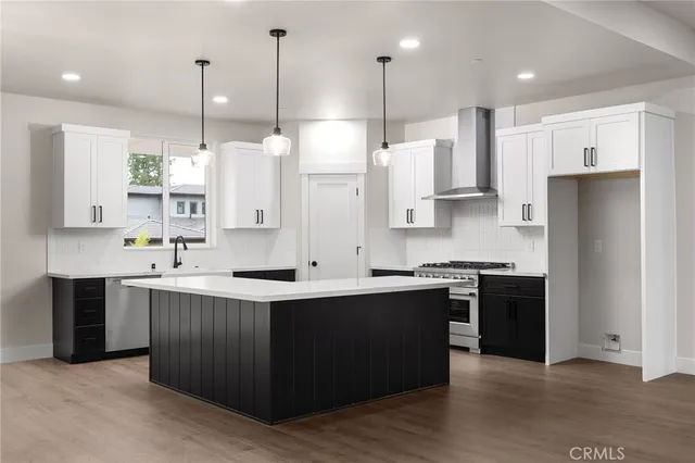 a large kitchen with stainless steel appliances kitchen island a large counter top and a view of living room
