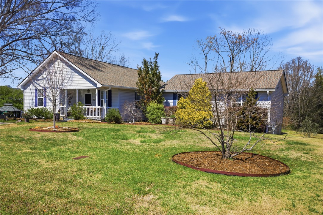 175 Burkett Road Seneca, SC 29672 - Photo 2 of 47 This charming residence offers a welcoming facade with a cozy front porch and a neatly manicured lawn.