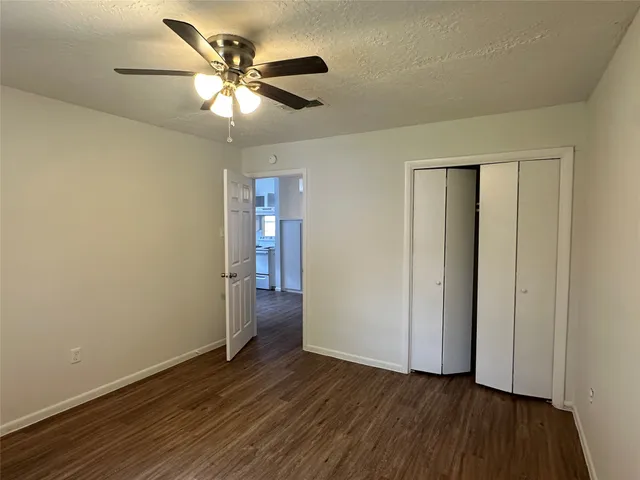 a view of an empty room with wooden floor