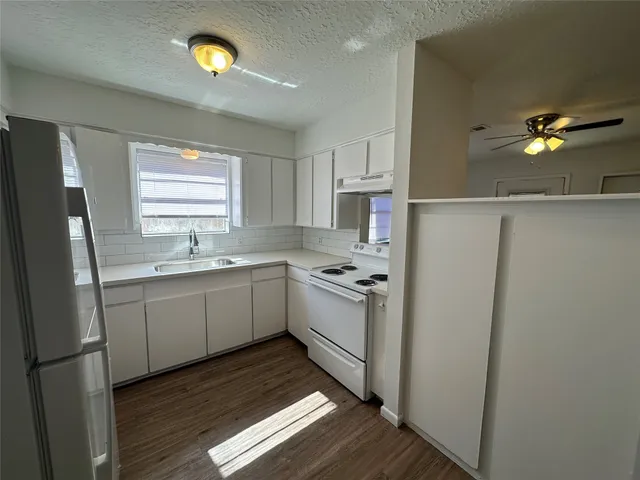 a kitchen with a sink appliances and cabinets