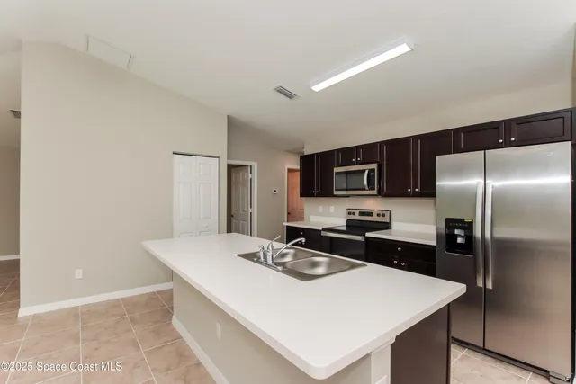 a kitchen with stainless steel appliances a sink and microwave
