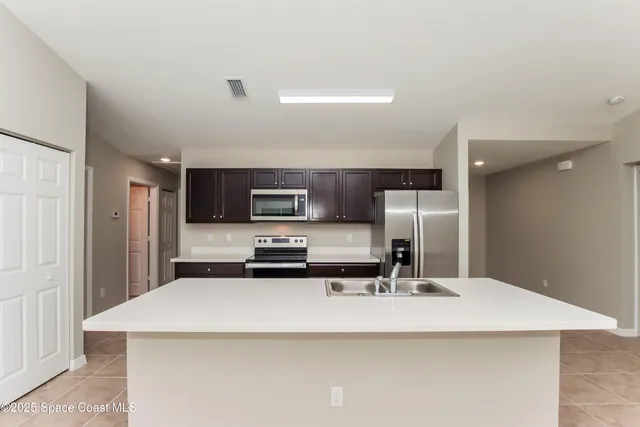 a kitchen with stainless steel appliances a sink and a refrigerator